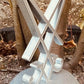 3D printed silver Sigil of Lucifer standing on a round base outdoors against tree bark background